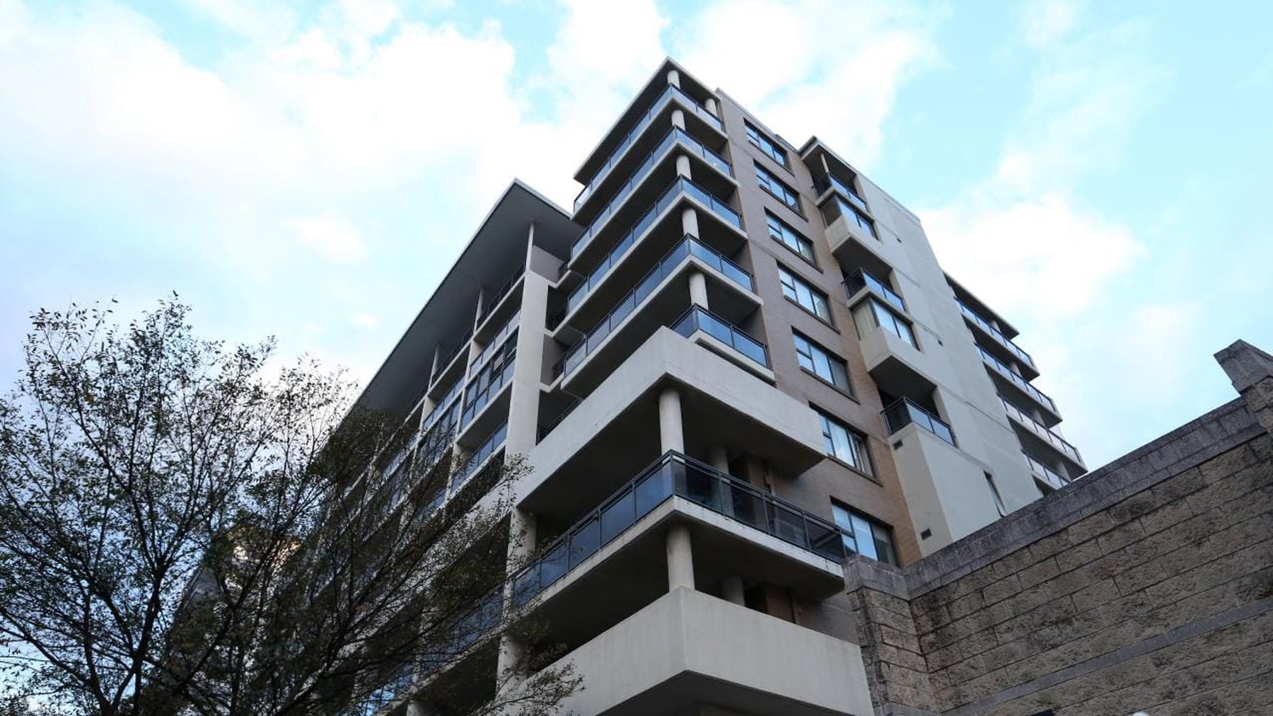 Low-angle view of a modern apartment tower, the kind of investment asset a pre-acquisition survey is often instructed on