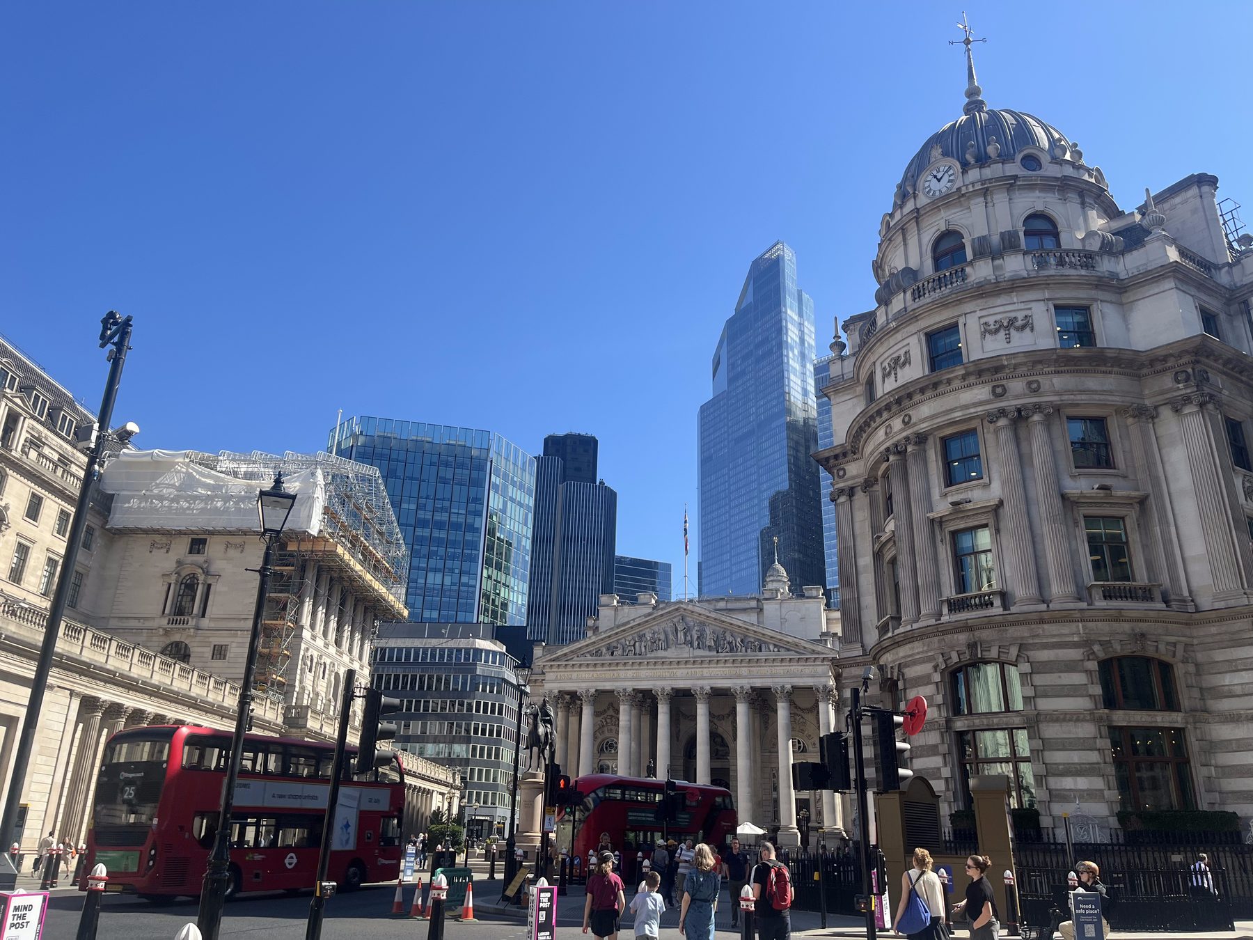 City of London street scene at the Bank junction, with the domed Royal Exchange building, modern office towers and a red double-decker bus